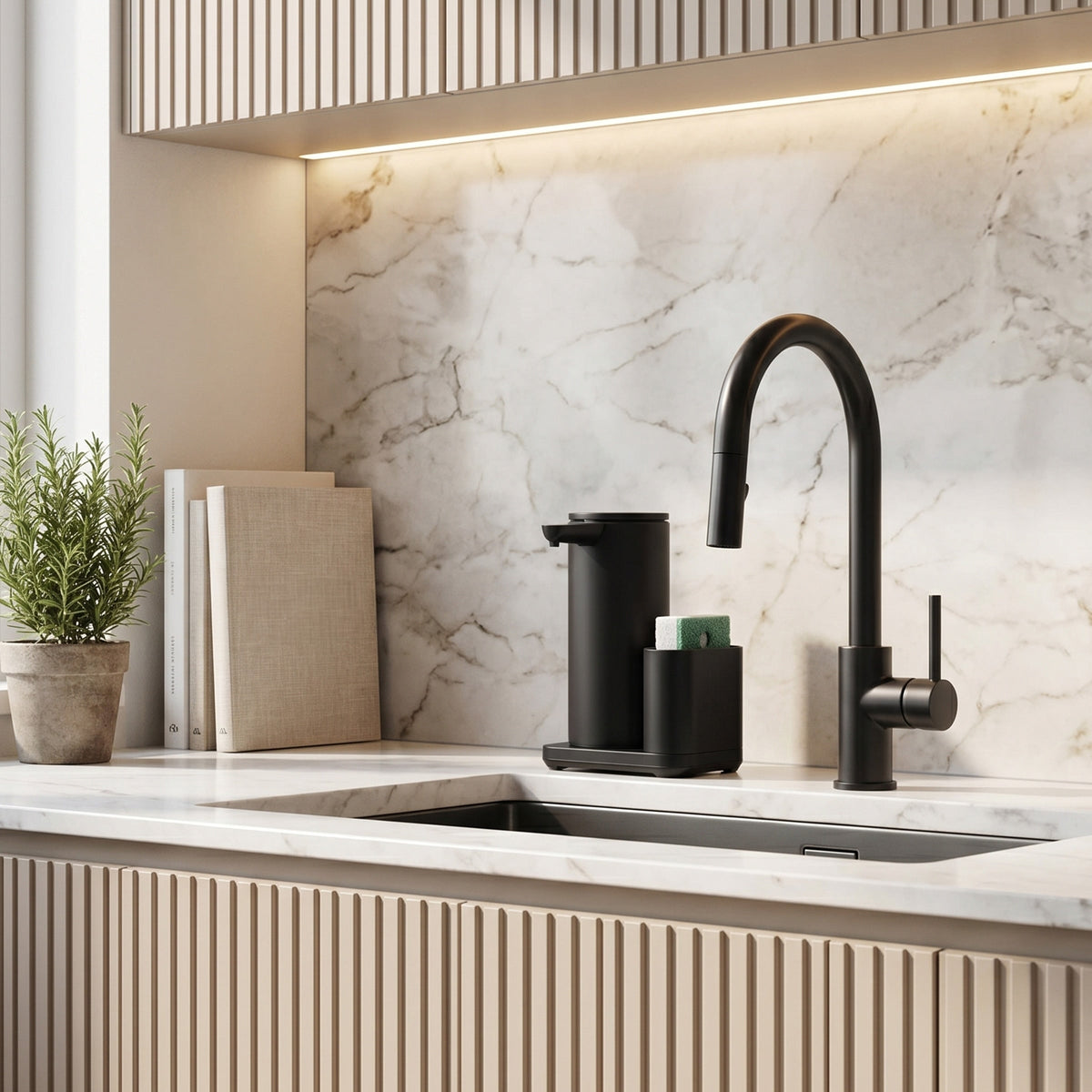 Simplehuman's 14 oz. Liquid Sensor Pump in Matte Black in a modern kitchen setting with marble countertops, books and small plants lining the counter and light wooden colored cabinets.